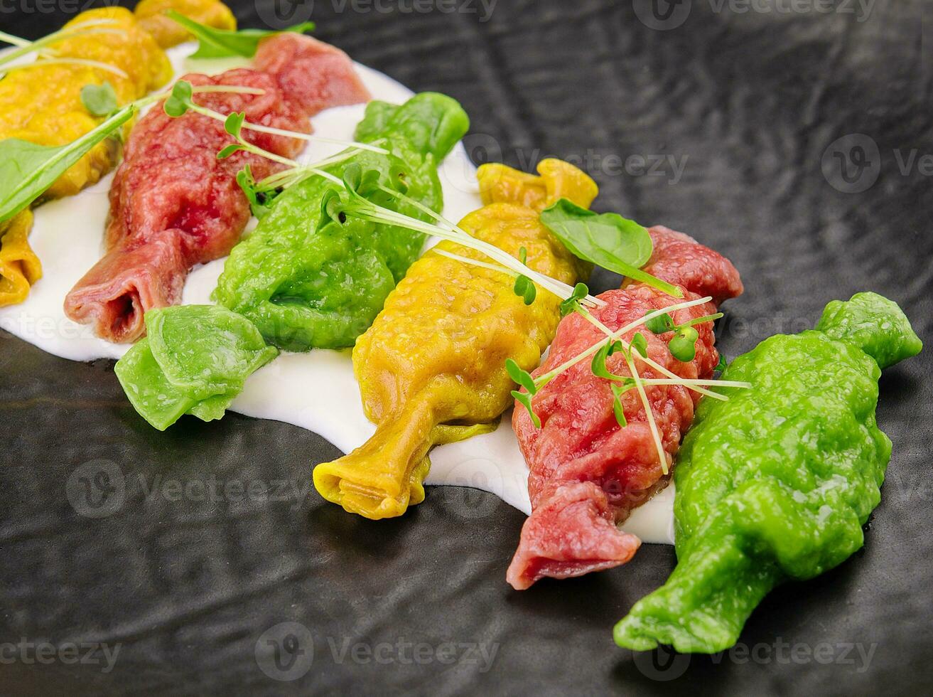 Chinese colourful steamed dumplings on black plate photo