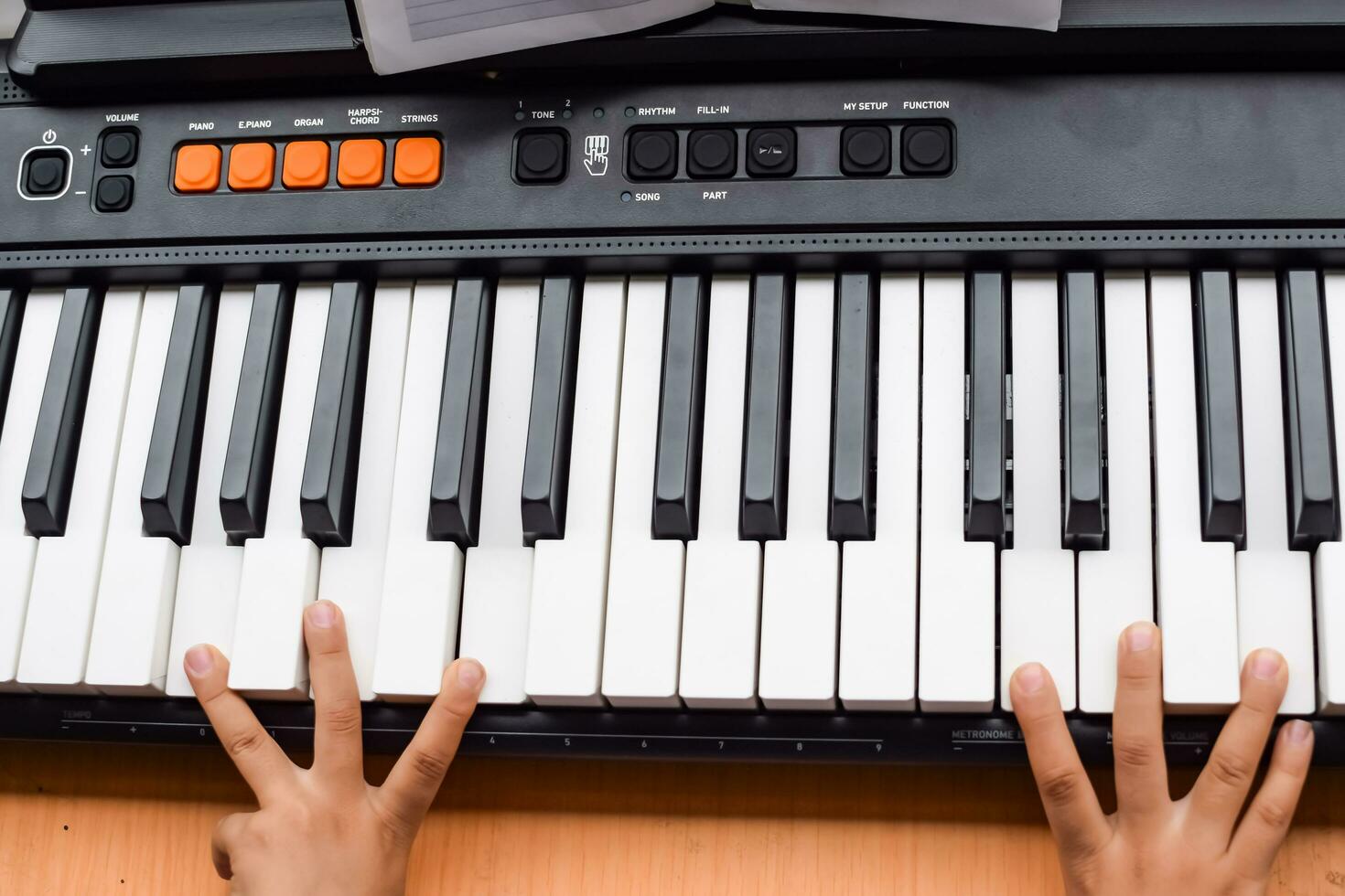 Asian boy playing the synthesizer or piano. Cute little kid learning how to play piano. Child's hands on the keyboard indoor. photo