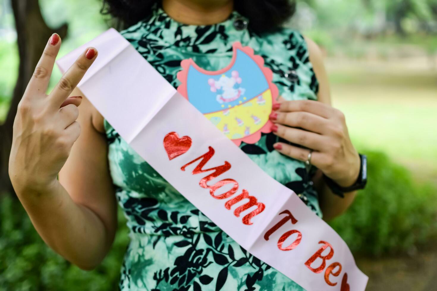 un embarazada indio dama poses para al aire libre el embarazo disparar y manos en barriga, indio embarazada mujer pone su mano en su estómago con un maternidad vestir a sociedad parque, embarazada fuera de maternidad disparar foto