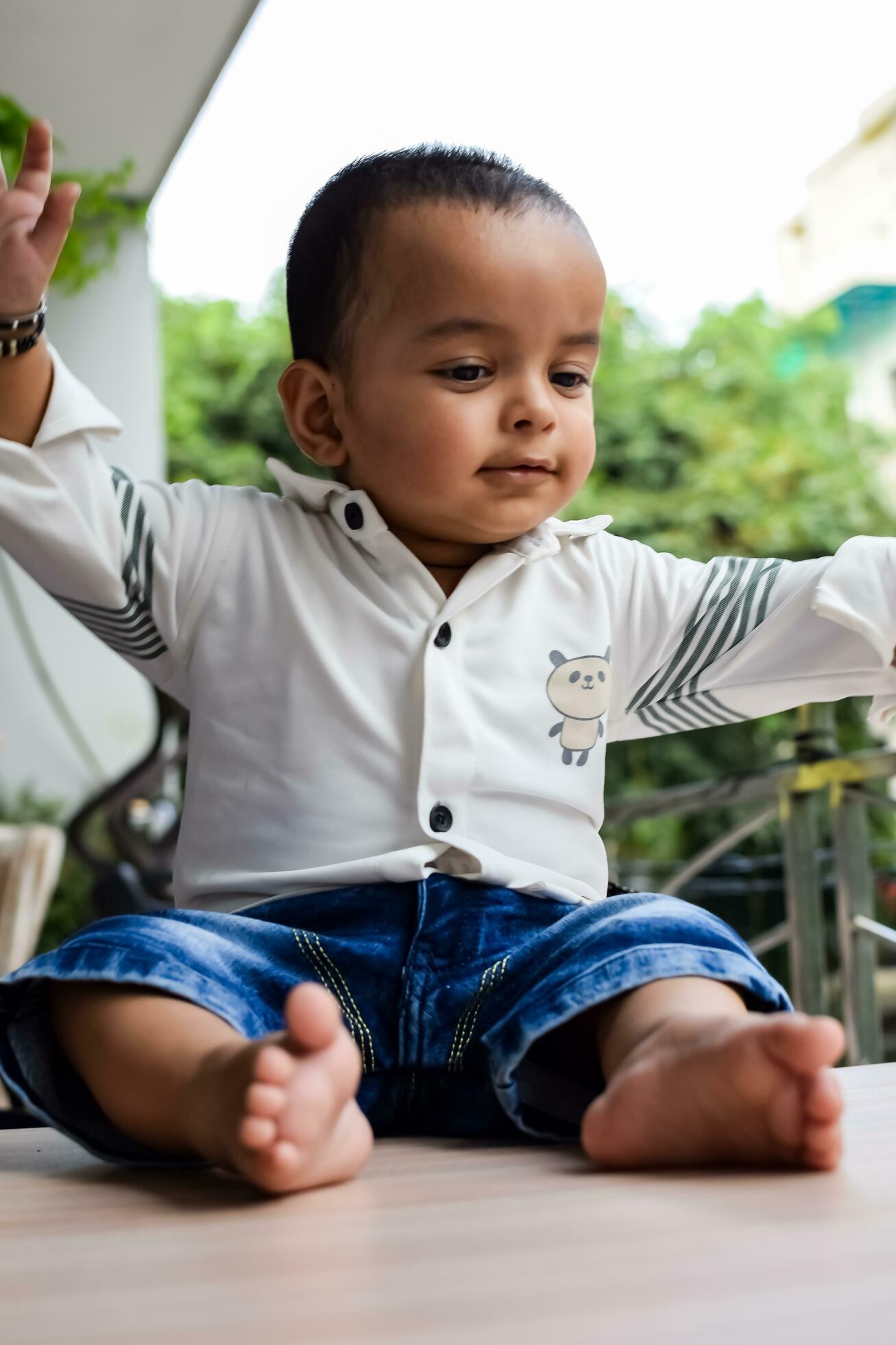 Baby boy at home balcony. Bright portrait of happy child sitting on the