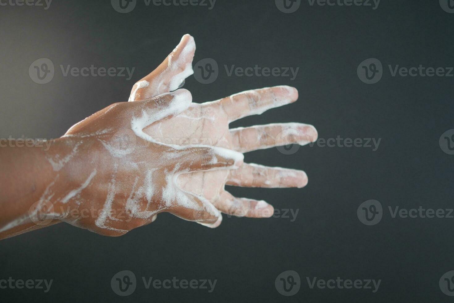 young man washing hands with soap warm water photo