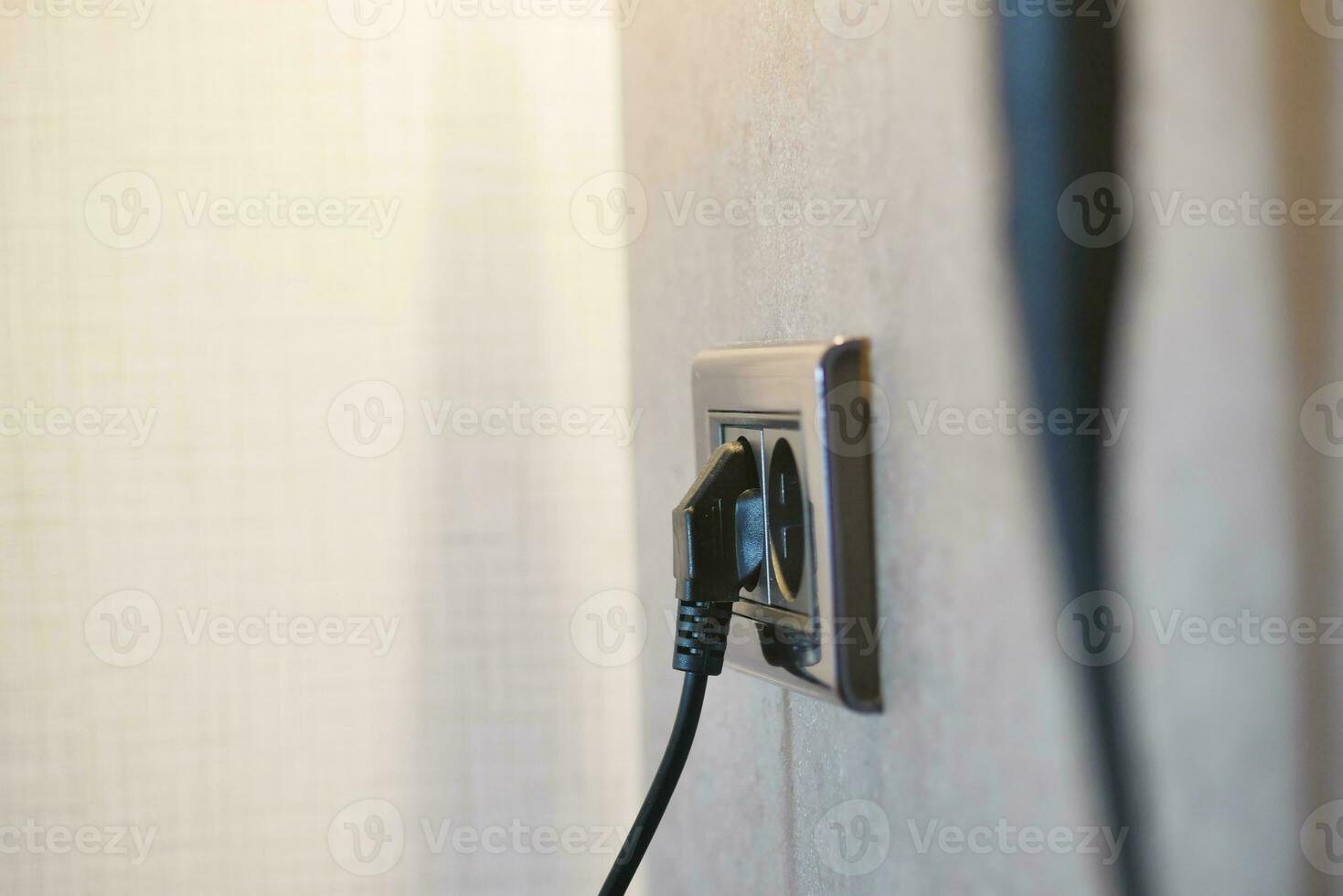 white color power cord cable plugged into wall photo