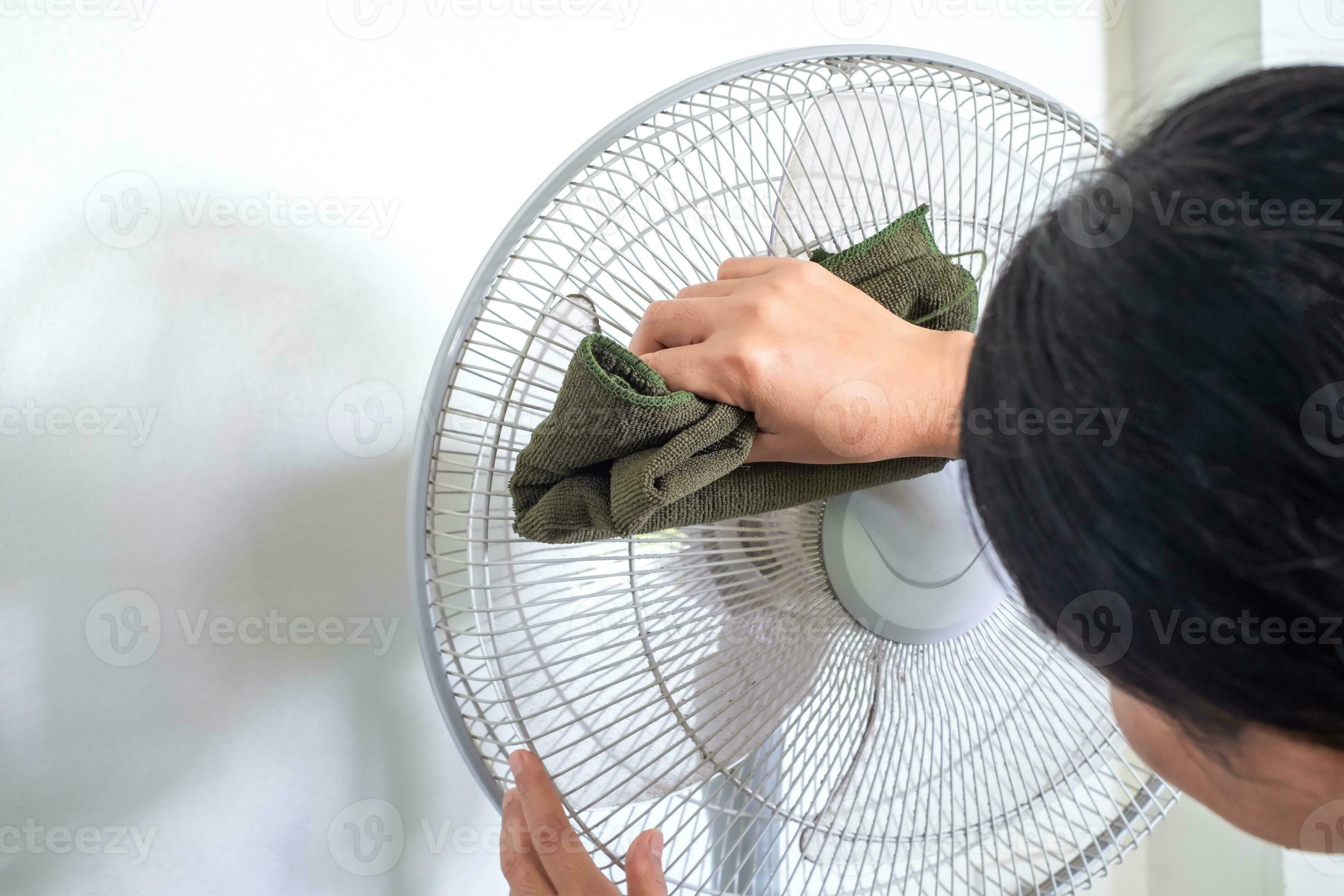 Close up hand touch rag dirty and dust on floor fan. unhealthy air flow