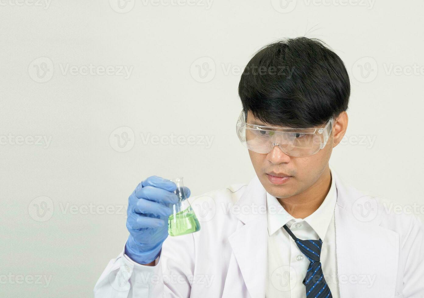 Asian man student scientist or doctor look hand holding in reagent mixing laboratory In a science research laboratory with test tubes of various sizes in  laboratory chemistry lab white background. photo