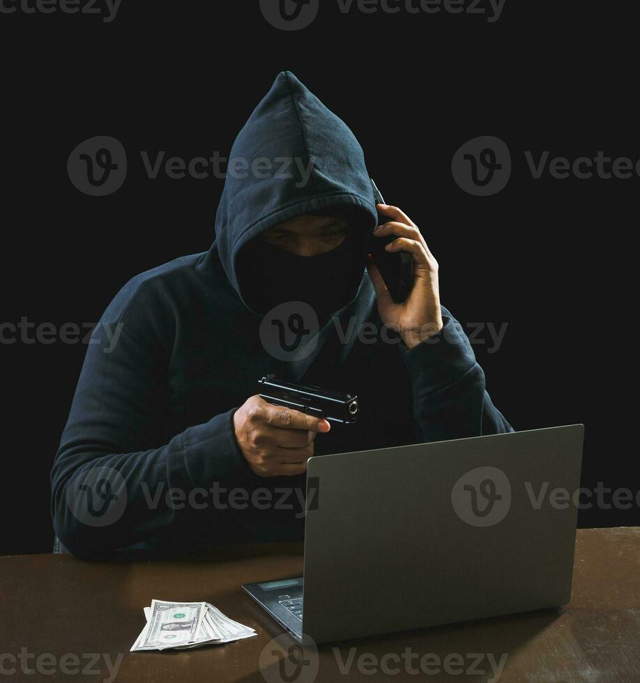 Hacker spy man one person in black hoodie sitting on a table looking computer laptop used login password attack security to circulate data digital in internet network system, night dark background. photo
