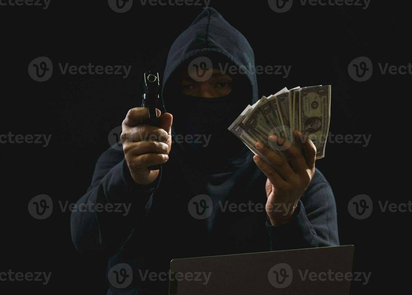 Hacker spy man one person in black hoodie sitting on a table looking computer laptop used login password attack security to circulate data digital in internet network system, night dark background. photo