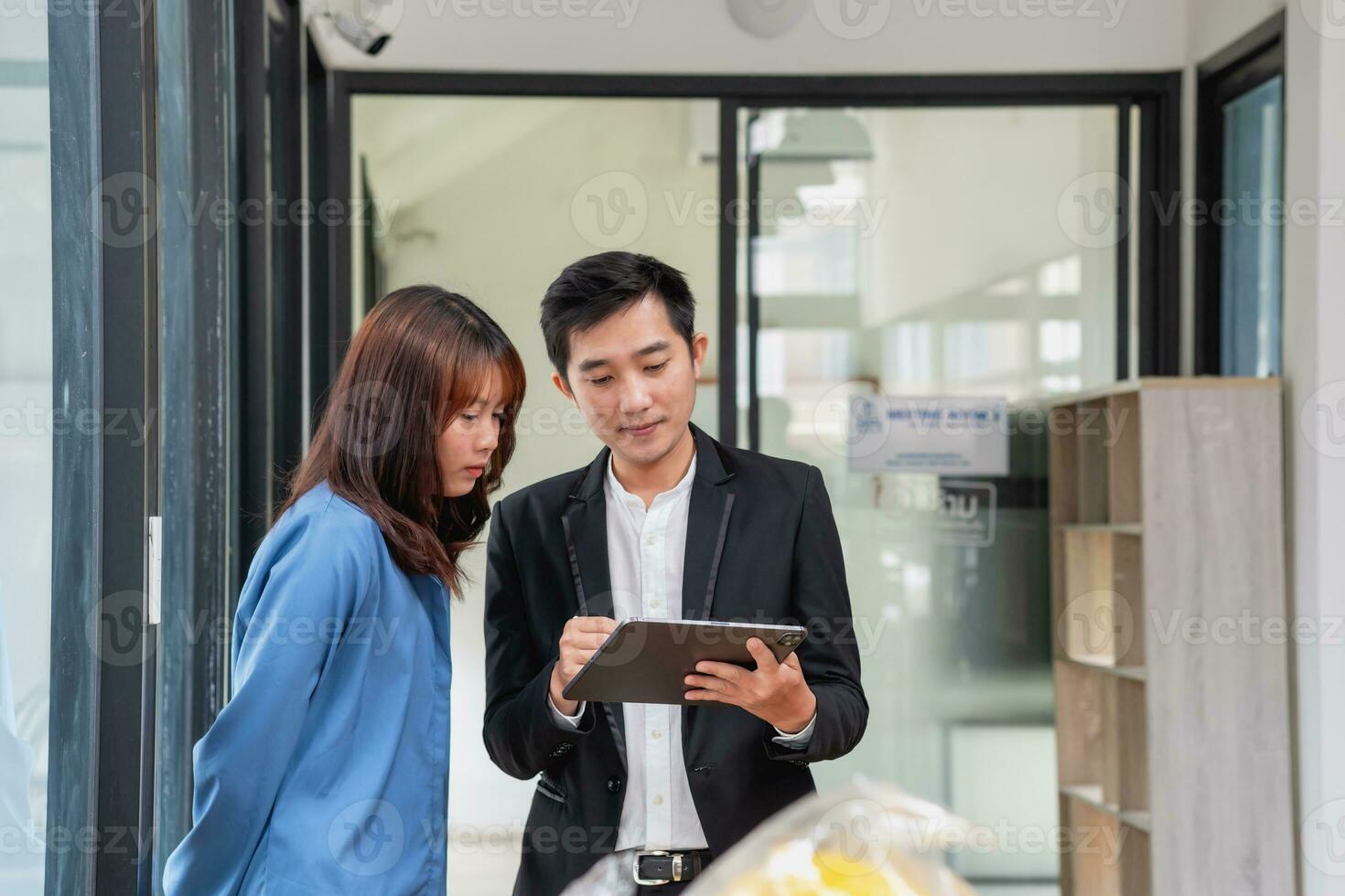 They are working, thinking, and planning on the tablet of a business team developing a project. The technology marketing group works with web research. Office workers are looking at tablets together. photo