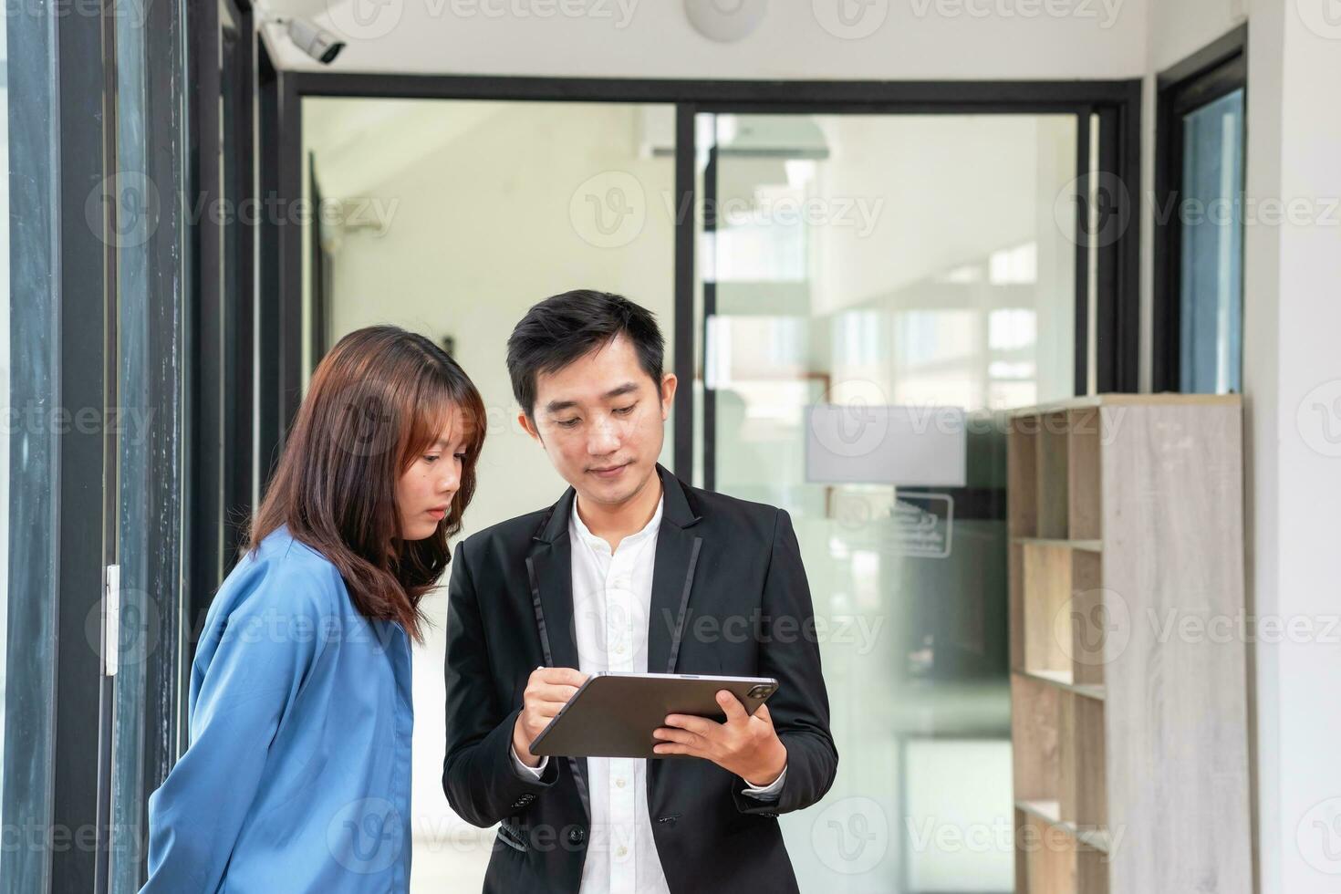They are working, thinking, and planning on the tablet of a business team developing a project. The technology marketing group works with web research. Office workers are looking at tablets together. photo
