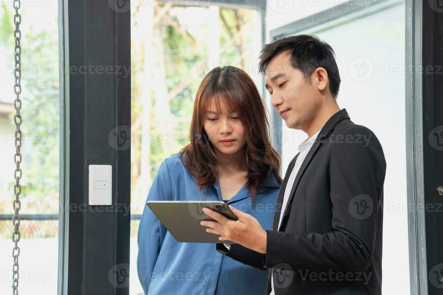 They are working, thinking, and planning on the tablet of a business team developing a project. The technology marketing group works with web research. Office workers are looking at tablets together. photo