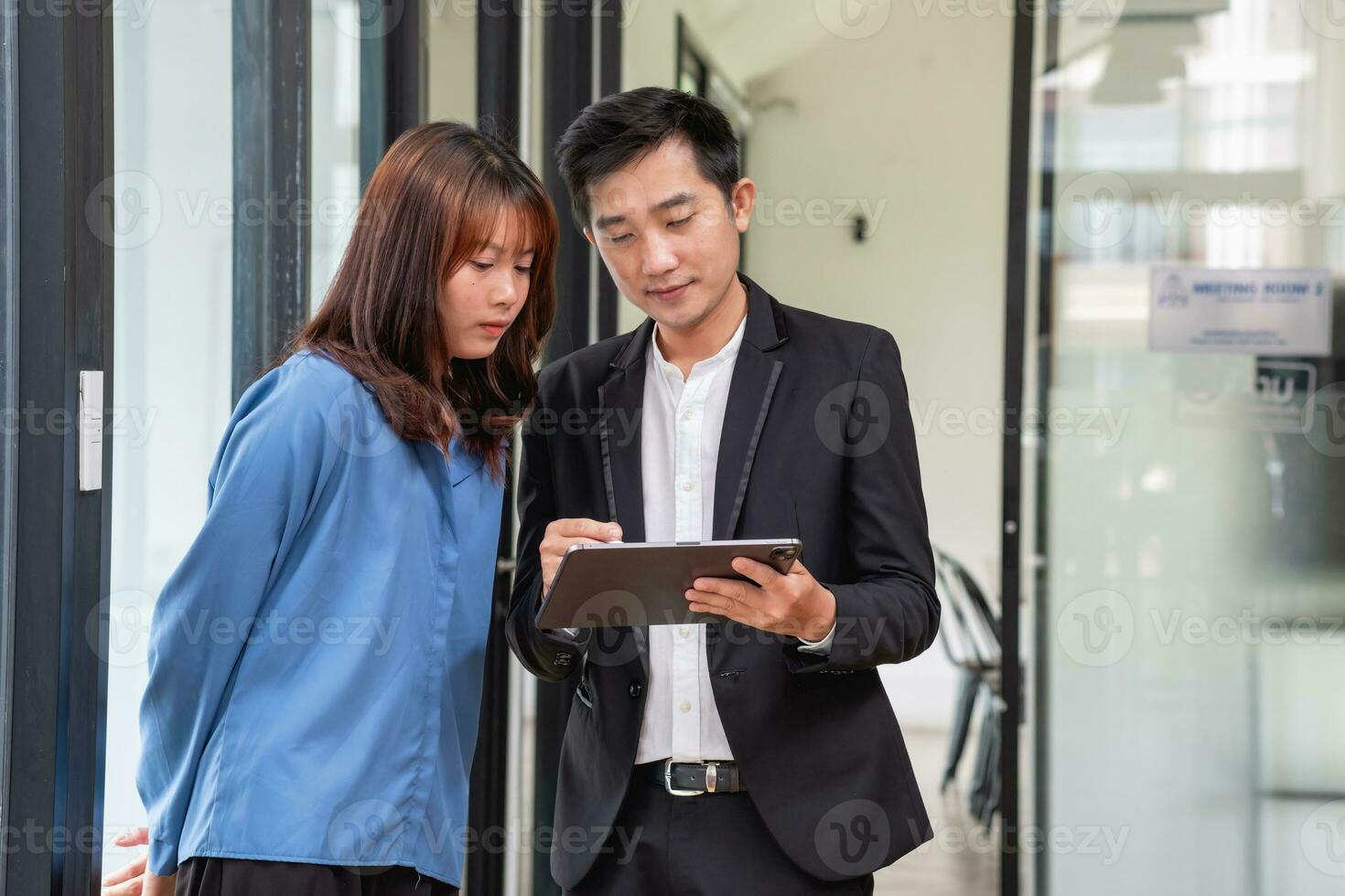 They are working, thinking, and planning on the tablet of a business team developing a project. The technology marketing group works with web research. Office workers are looking at tablets together. photo