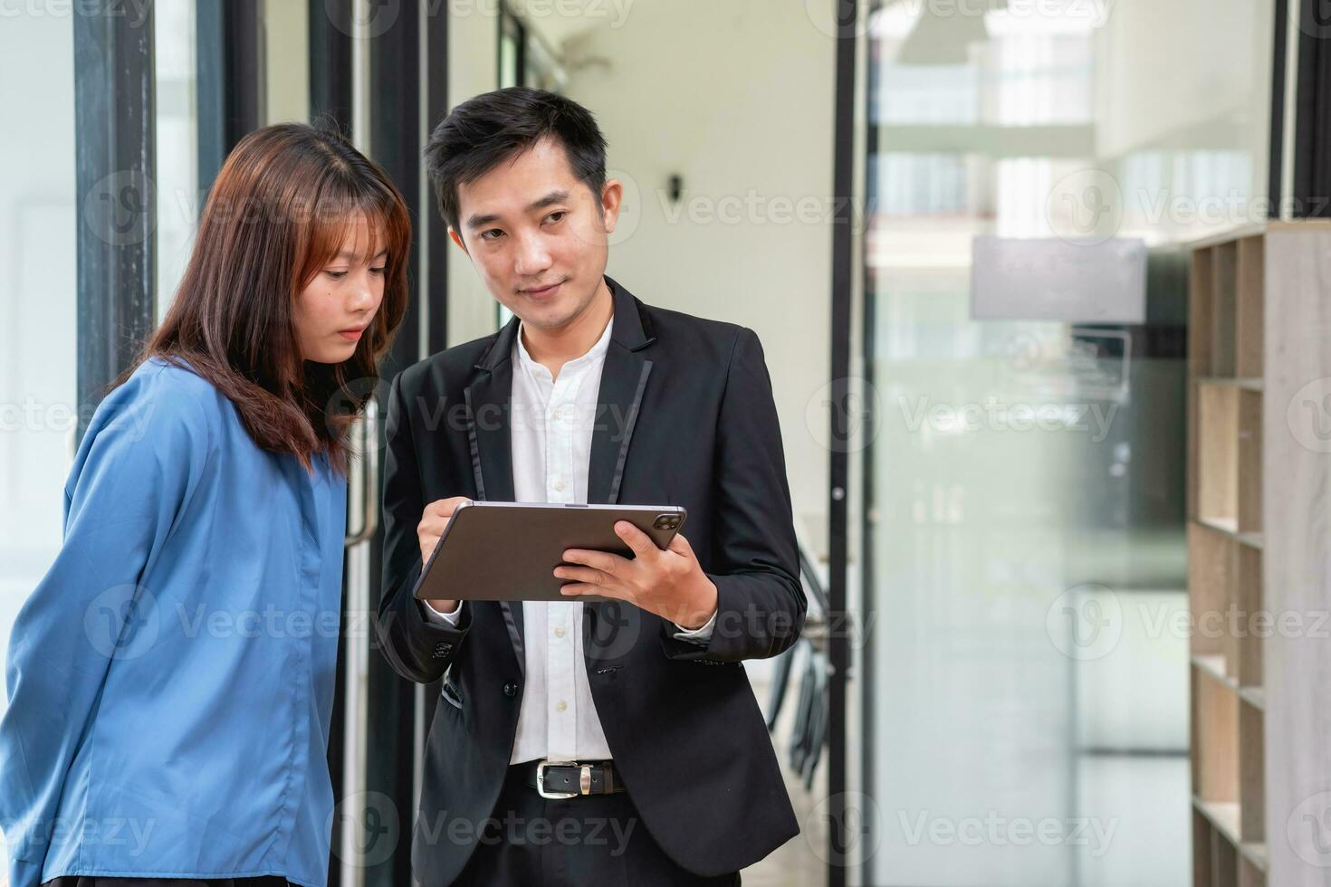 They are working, thinking, and planning on the tablet of a business team developing a project. The technology marketing group works with web research. Office workers are looking at tablets together. photo