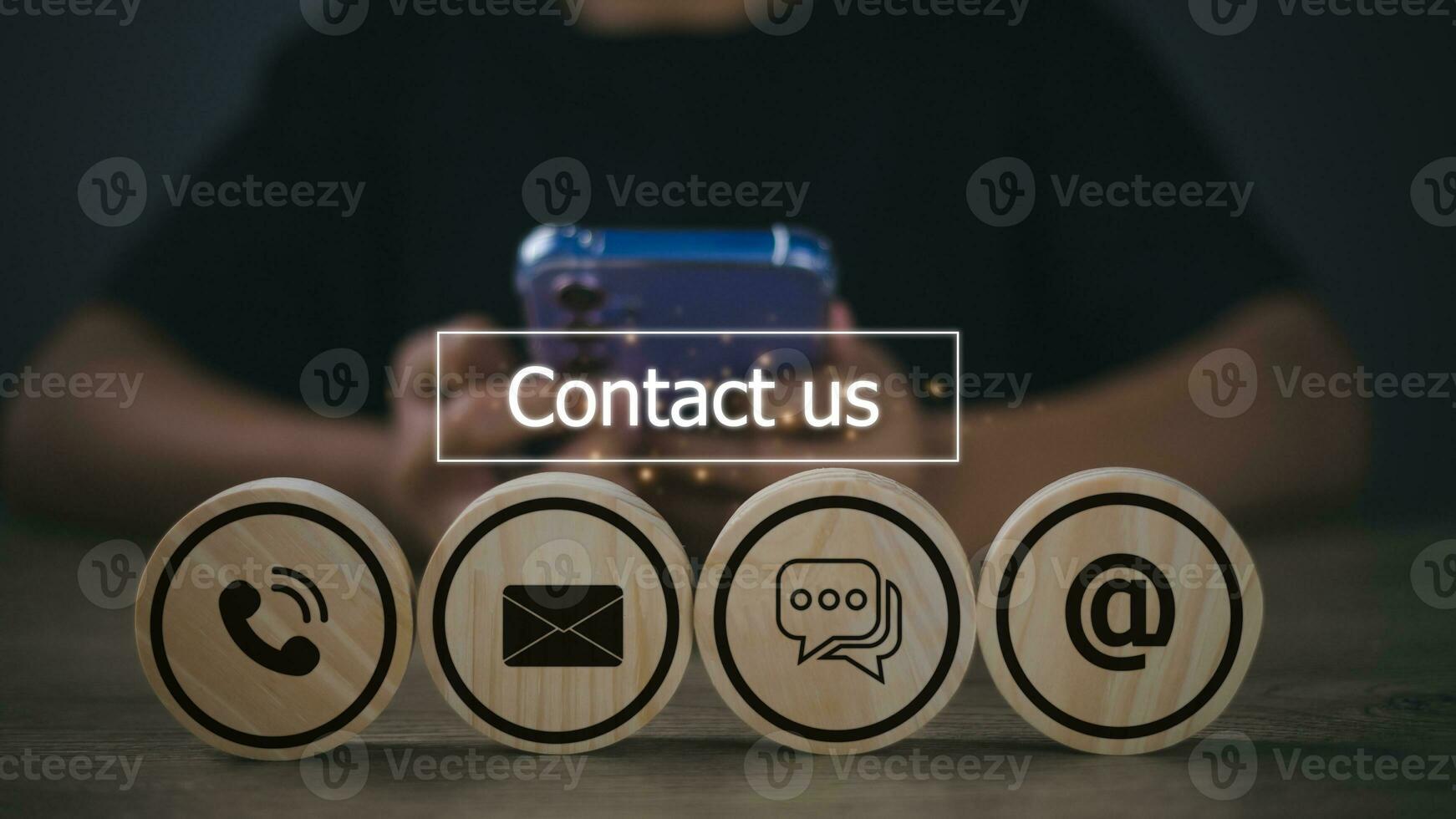 Contact Us concept with icons on wooden blocks. Man is using a smartphone. customer support concept photo