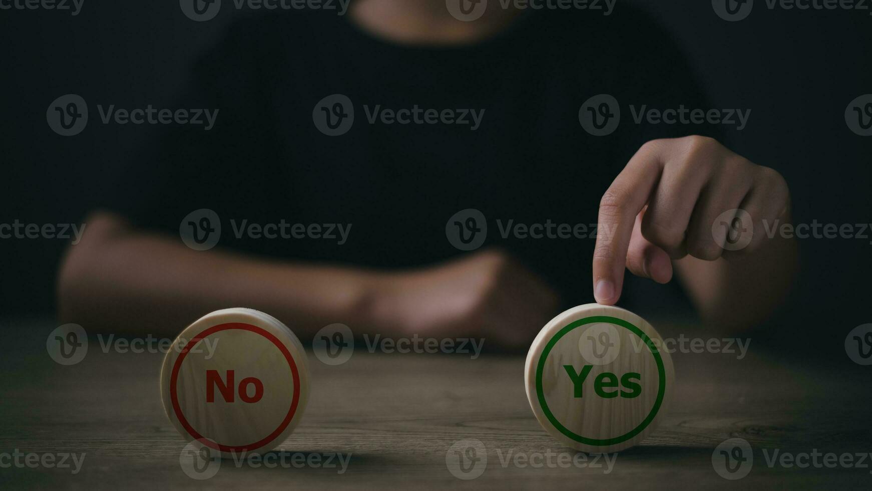 Close up image of man's hand putting wooden dice with yes and no signs photo