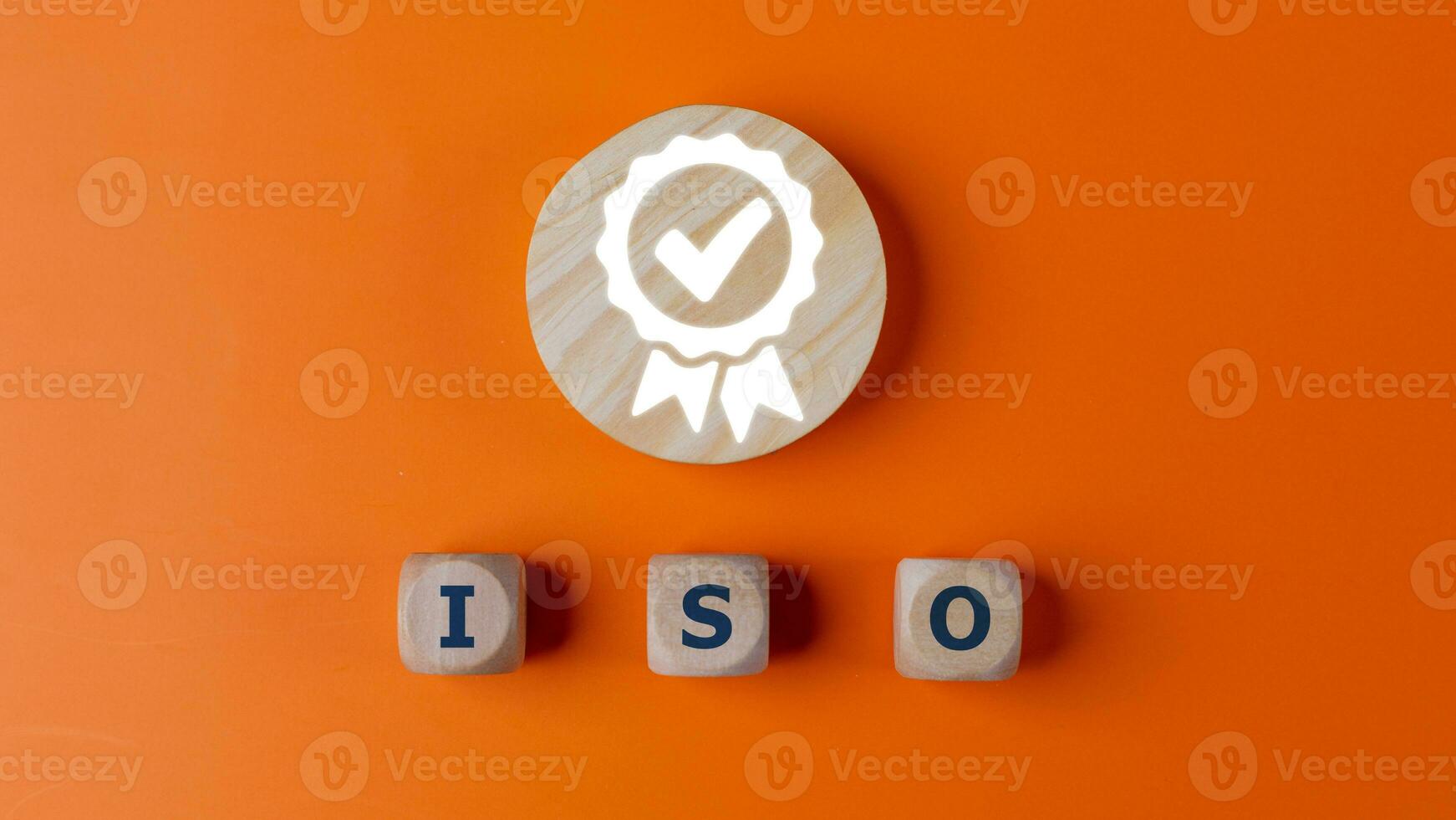 ISO quality control certification concept, top view of wooden blocks with word ISO and certificate sign. on an orange background. photo