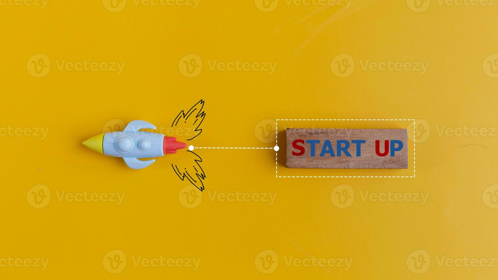 The start up concept with rocket pulls a wooden banner with the word START UP on a yellow background. photo