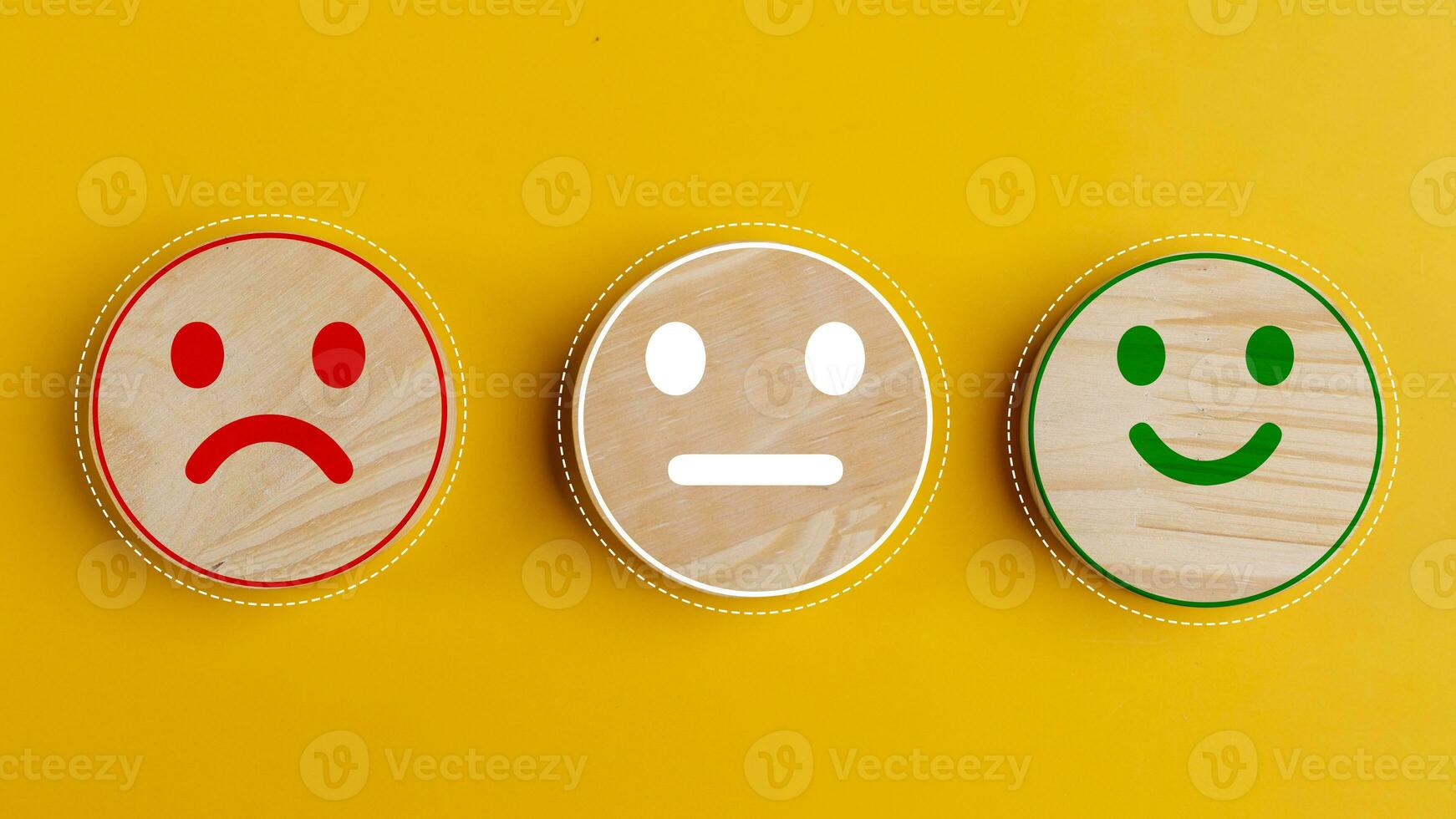 Concept of customer satisfaction. Happy sad and neutral smile faces on wooden blocks on a yellow background. Customer satisfaction, evaluation, or feedback concept. photo