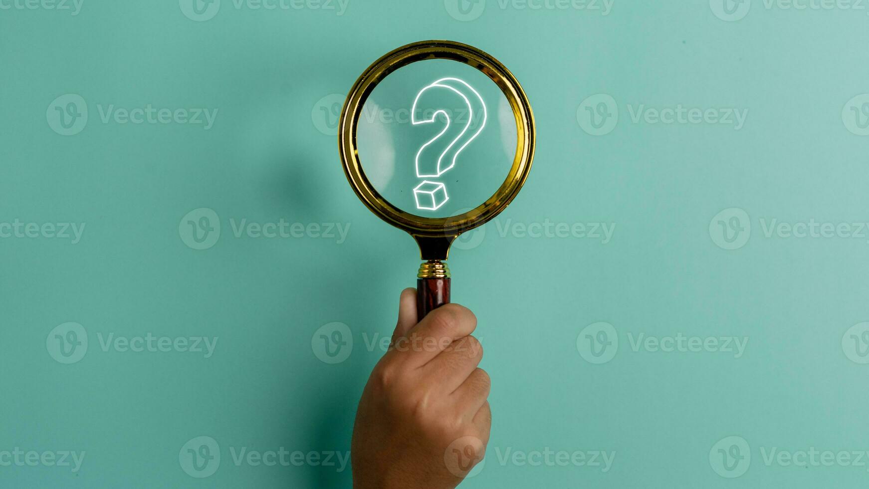 Hand holding a magnifying glass with a question mark icon on the blue background with copy space. Problem solving troubleshooting education concept. photo
