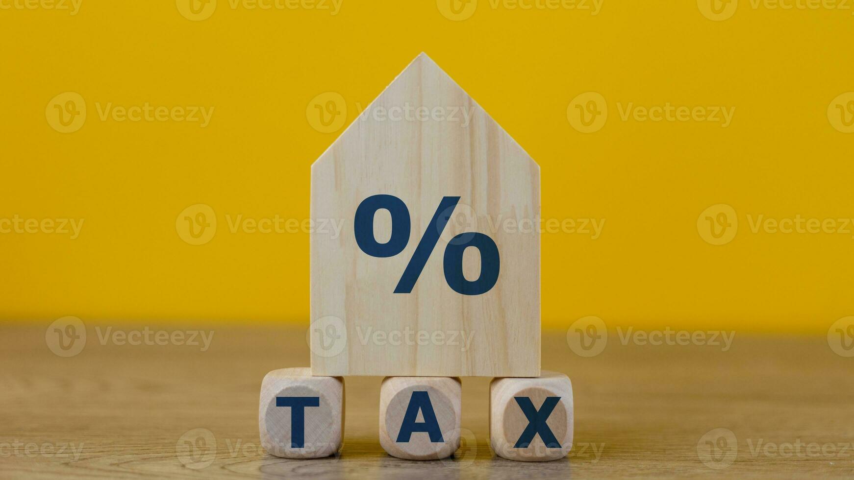 Property tax concept. investment planning.Wooden blocks with the word TAXES and a house on a yellow background. photo