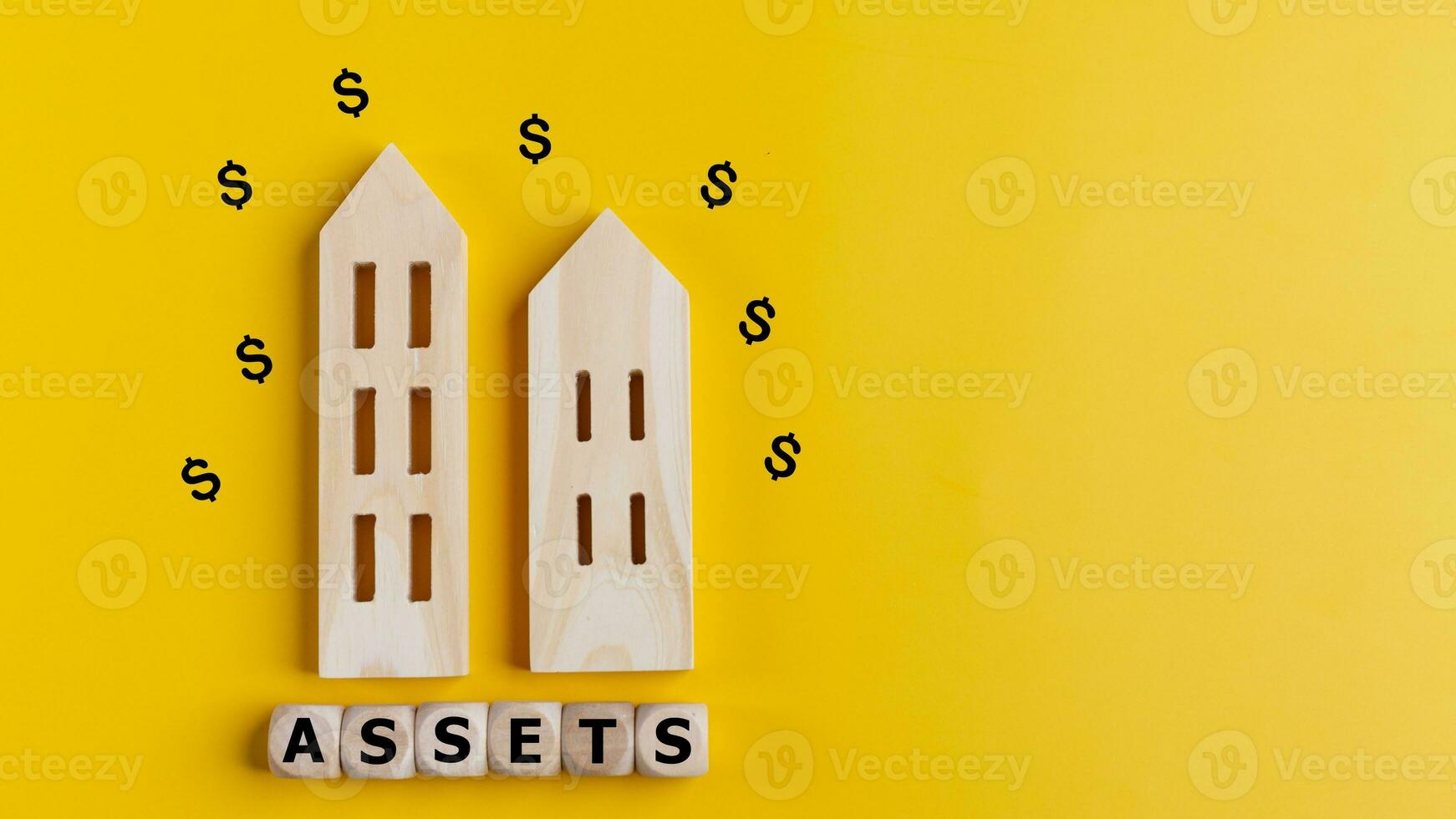 el palabra bienes en de madera cubitos con un bienes icono en un amarillo antecedentes. activo administración o financiero contabilidad concepto. foto