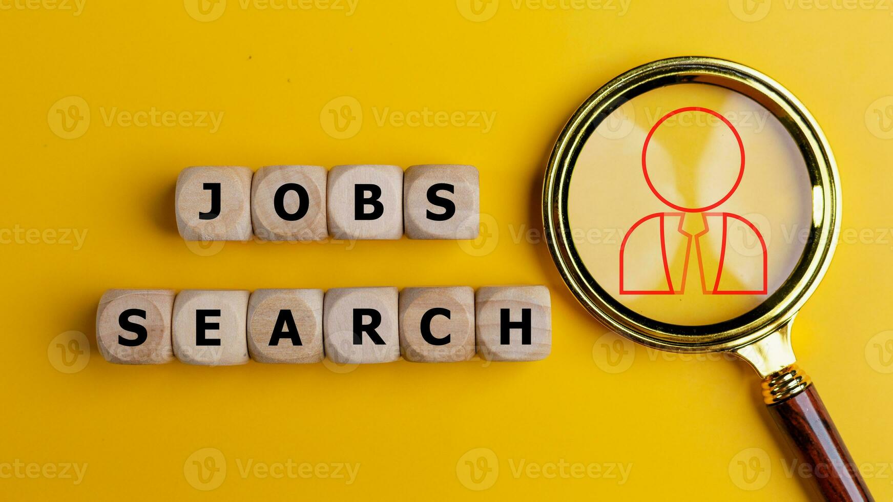 Job search concept. Magnifying glass and wooden cubes with the word job search photo