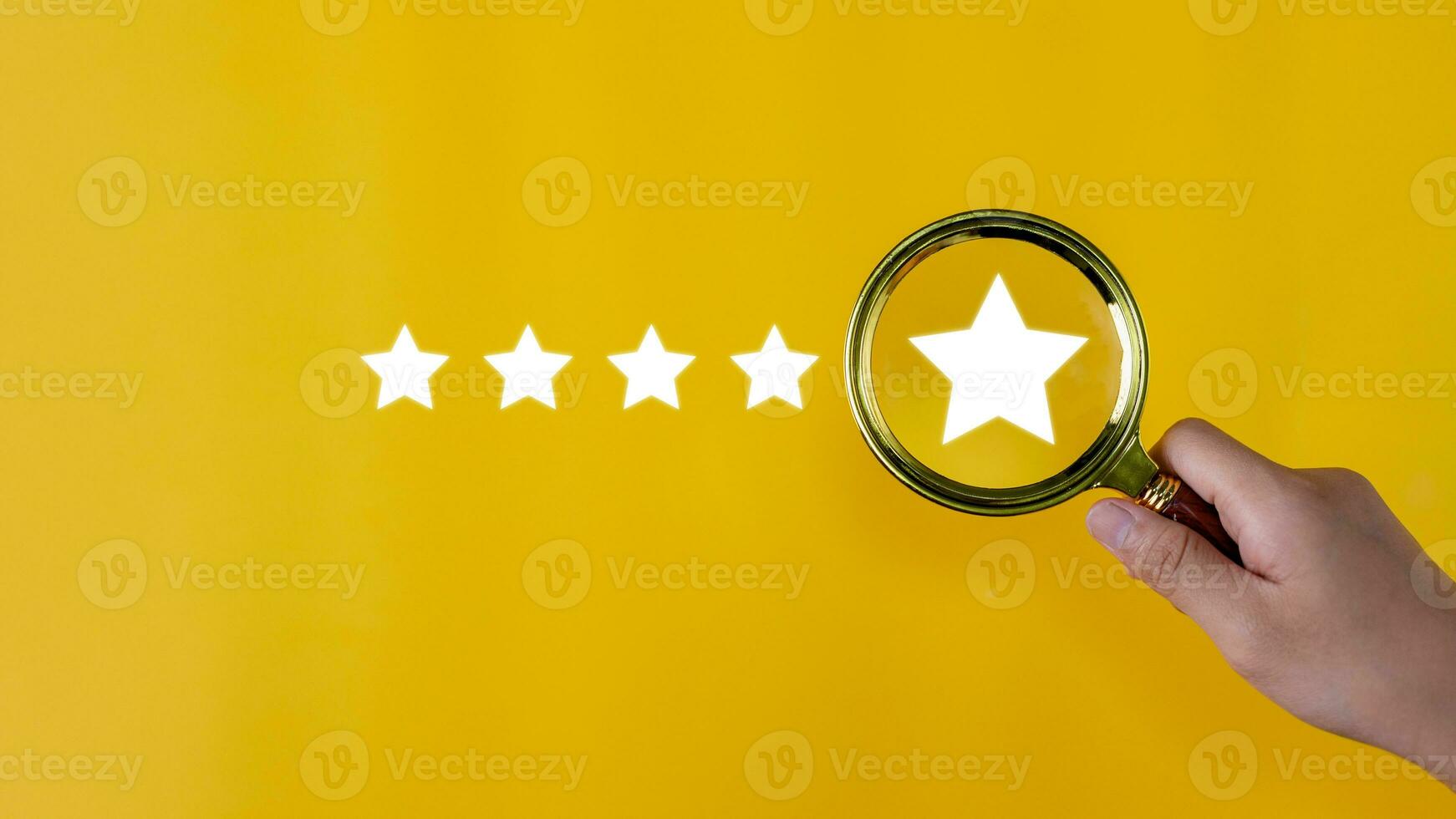 Hand holding a magnifying glass with a five-star rating on a yellow background. feedback review satisfaction service, Customer service experience, and business satisfaction survey. photo