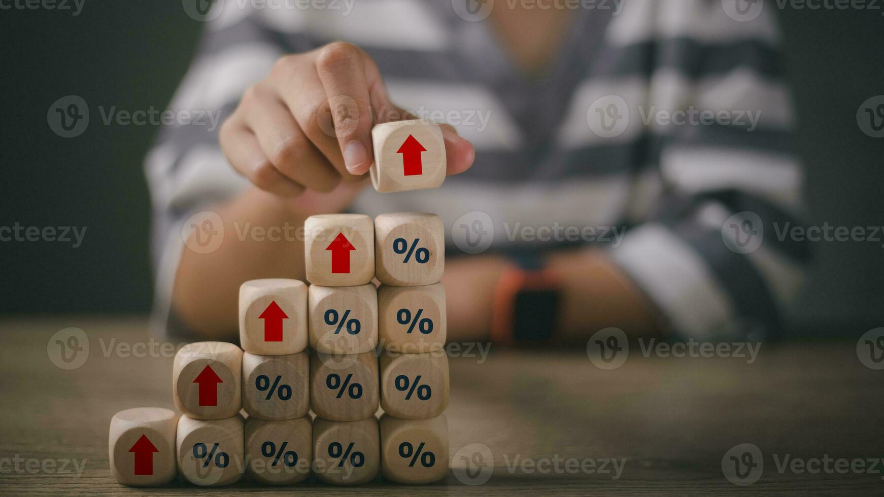 Hand stacking wooden cubes with arrow up and percent sign. percentage symbol and up arrow, Interest rates continue to increase, return on stocks and mutual funds, Interest rate, and dividend concept photo