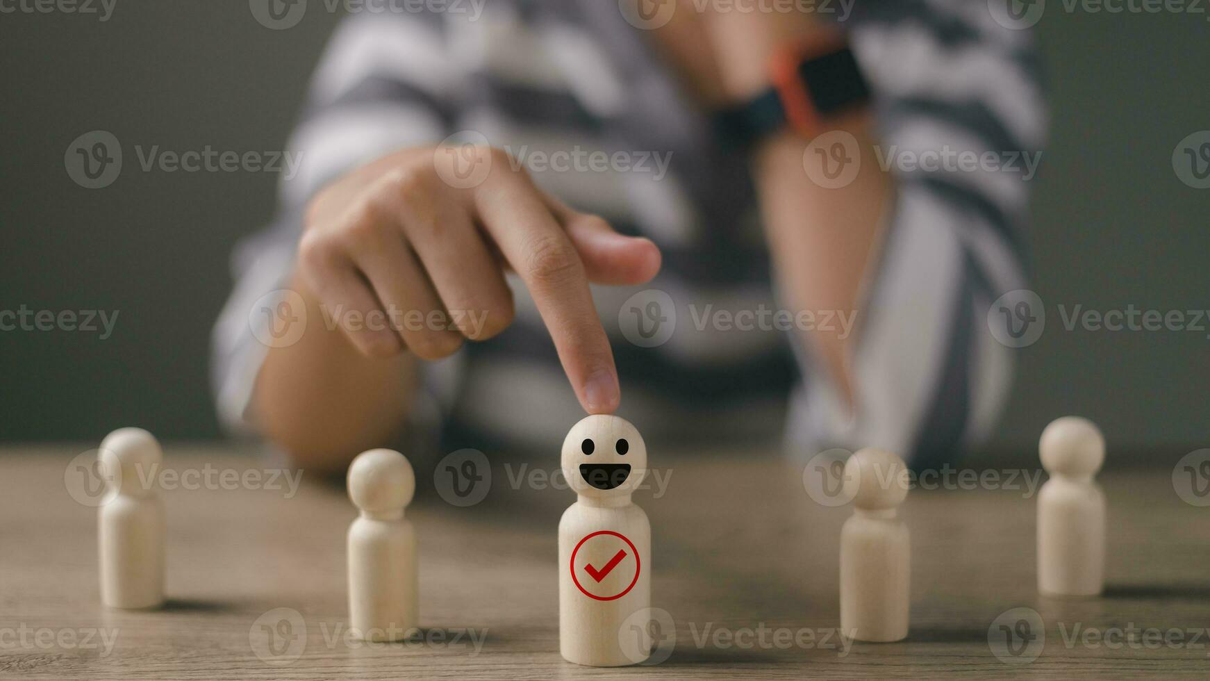 Woman pick a happy face wooden figure. Customer rating employees by service experience, Human Resources management choose a positive attitude leader for team. resources management and recruitment. photo