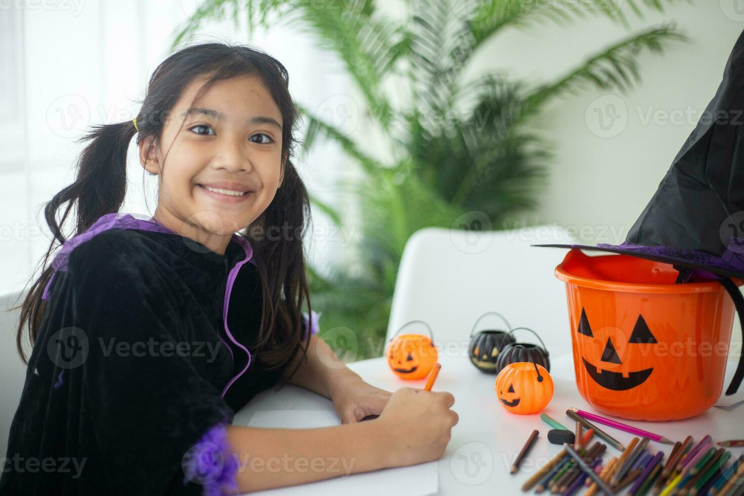 Happy Asian child girl in a witch costume to Halloween. trick or treat. Kids trick or treating. photo