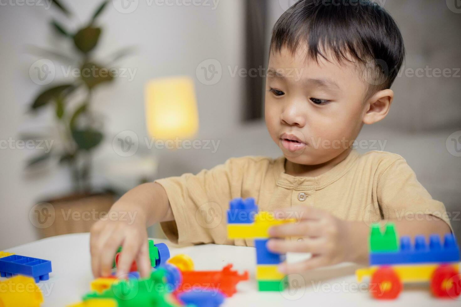 The kid playing with colorful toy blocks. Little boy building the car of block toys. Educational and creative toys and games for young children. photo