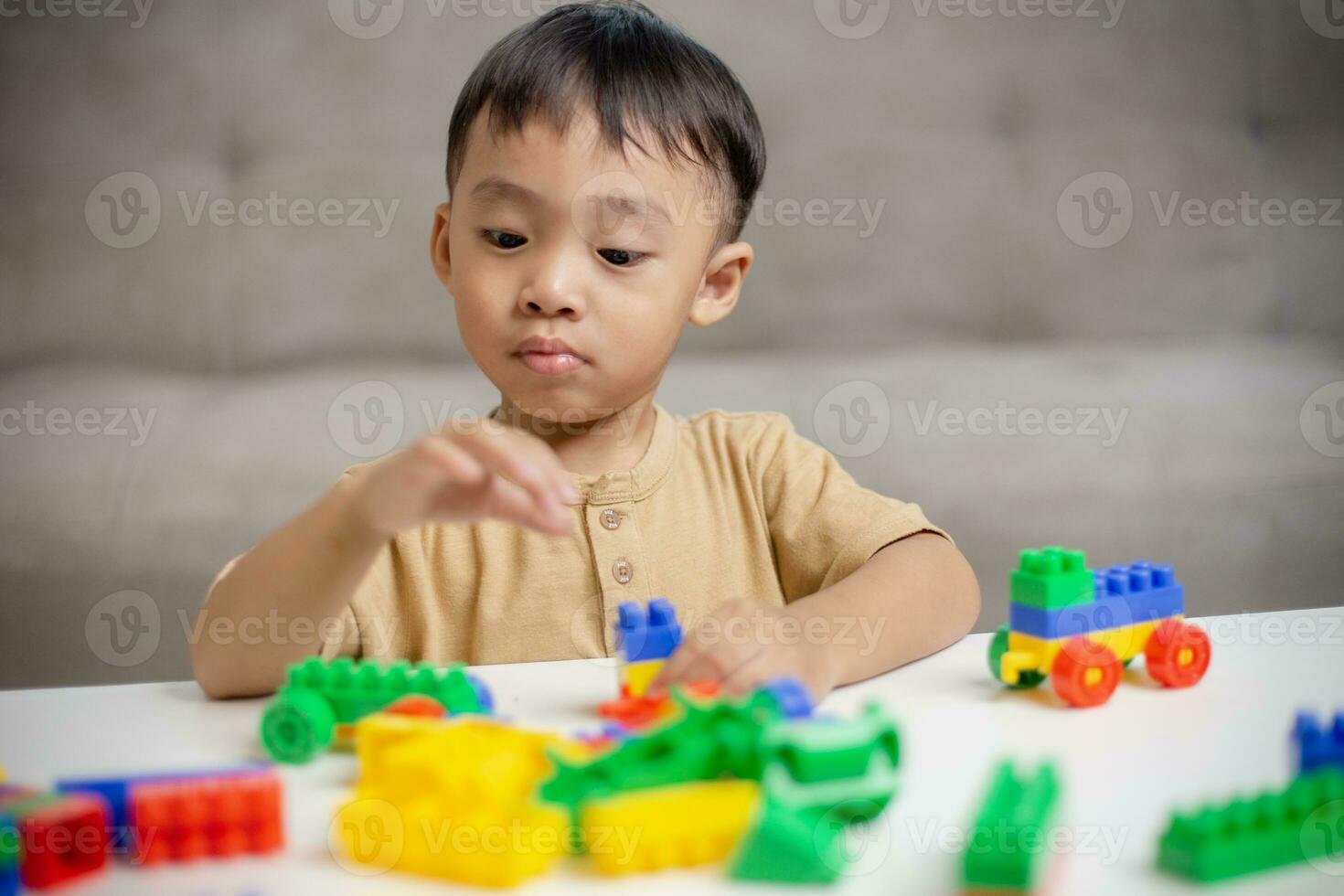 The kid playing with colorful toy blocks. Little boy building the car of block toys. Educational and creative toys and games for young children. photo