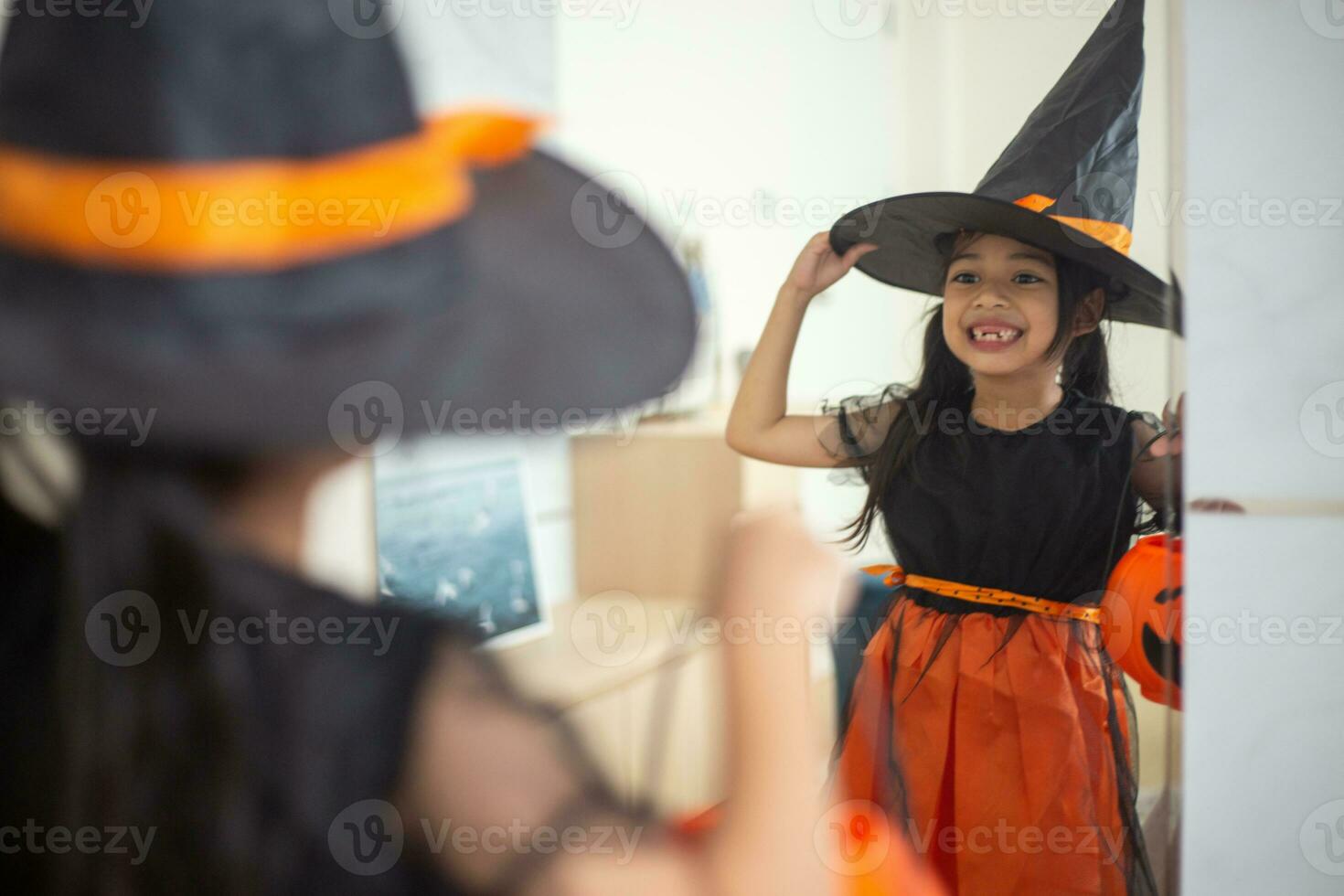 contento asiático niño niña en un bruja disfraz a Víspera de Todos los Santos. truco o tratar. niños truco o tratando. foto