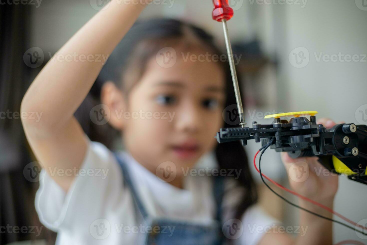 STEM education concept. Asian young girl learning robot design. photo