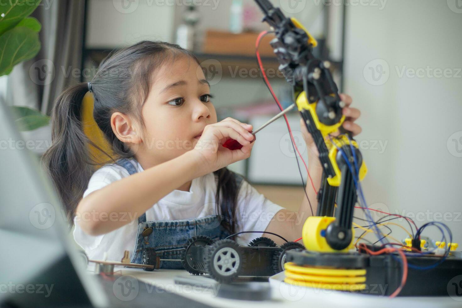 STEM education concept. Asian young girl learning robot design. photo