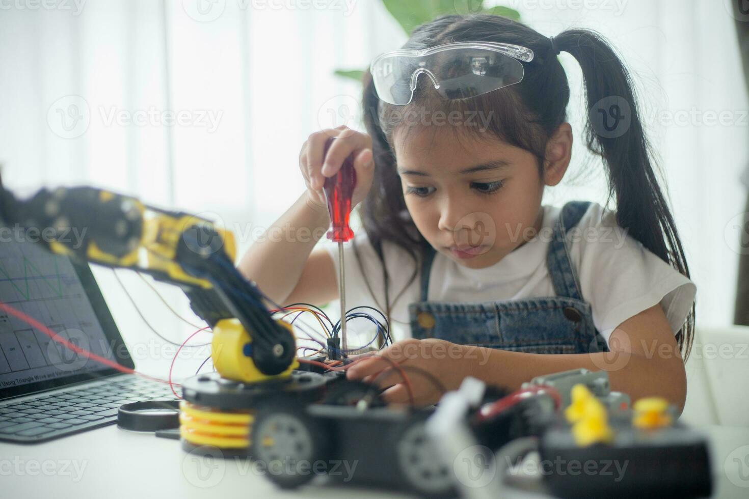 vástago educación concepto. asiático joven niña aprendizaje robot diseño. foto