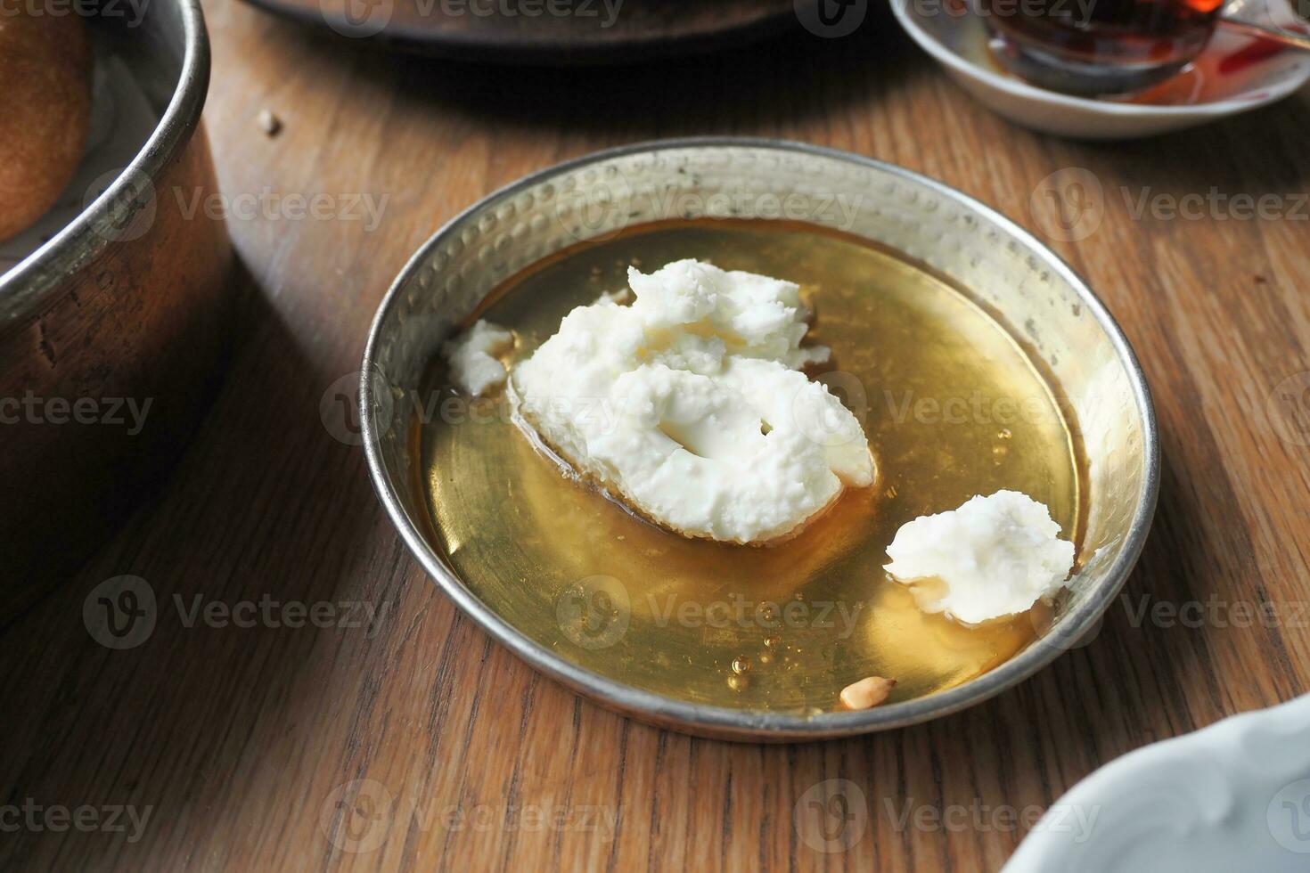 butter cream and honey in a bowl on table . photo