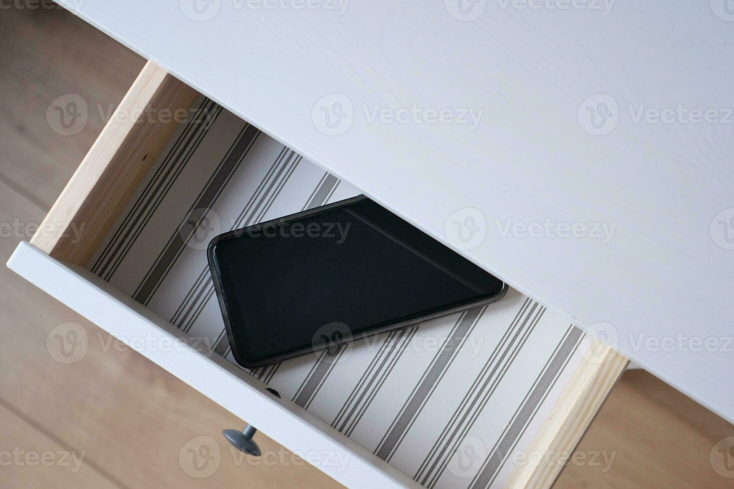 mobile phone in open drawer. photo