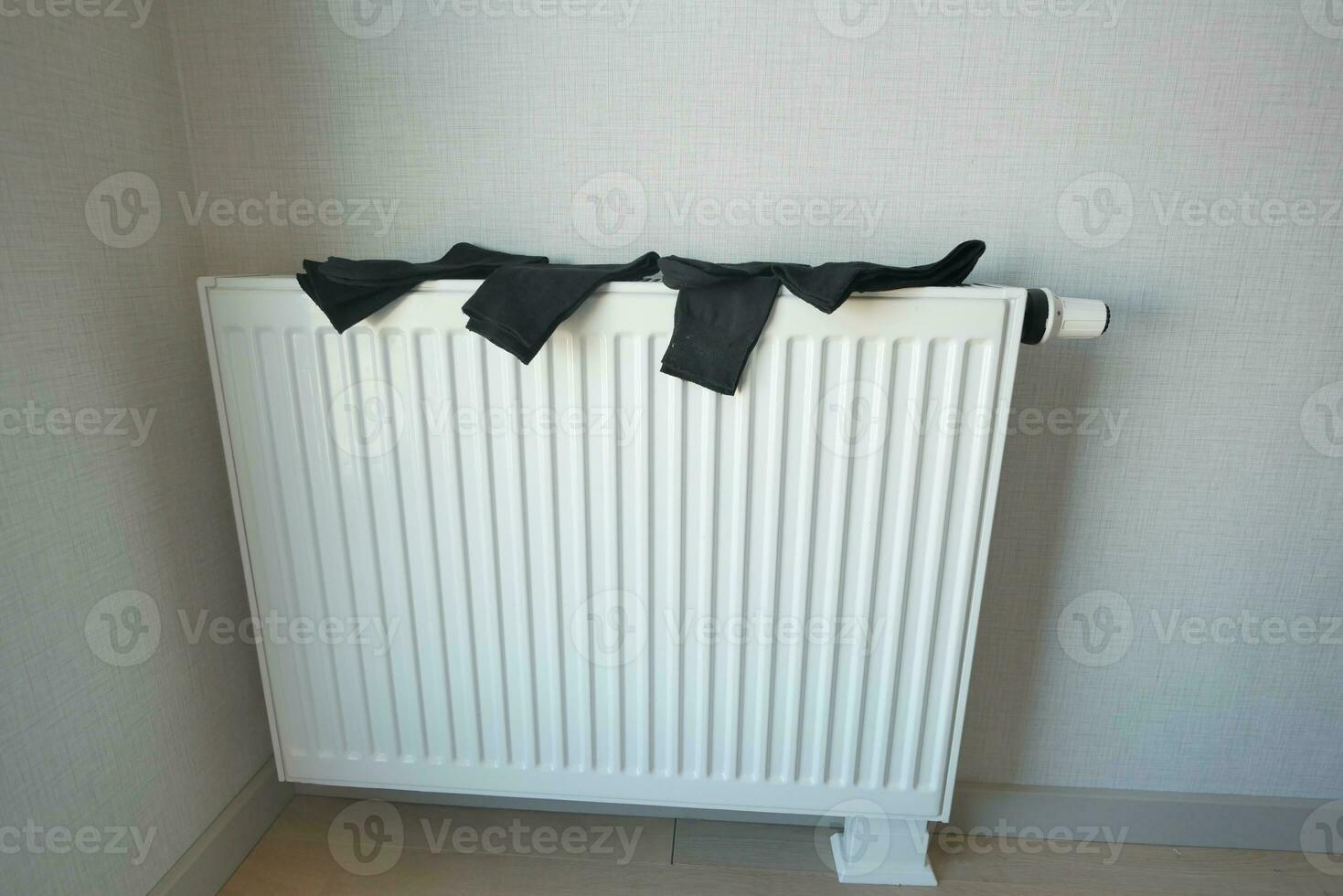 black sock drying on heating radiator, photo