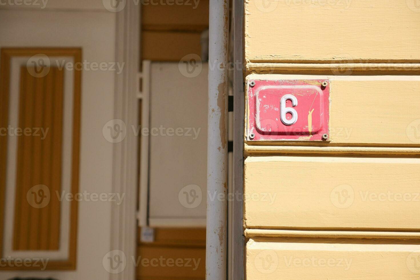 house number six. Decorative lettering on a brick wall. photo