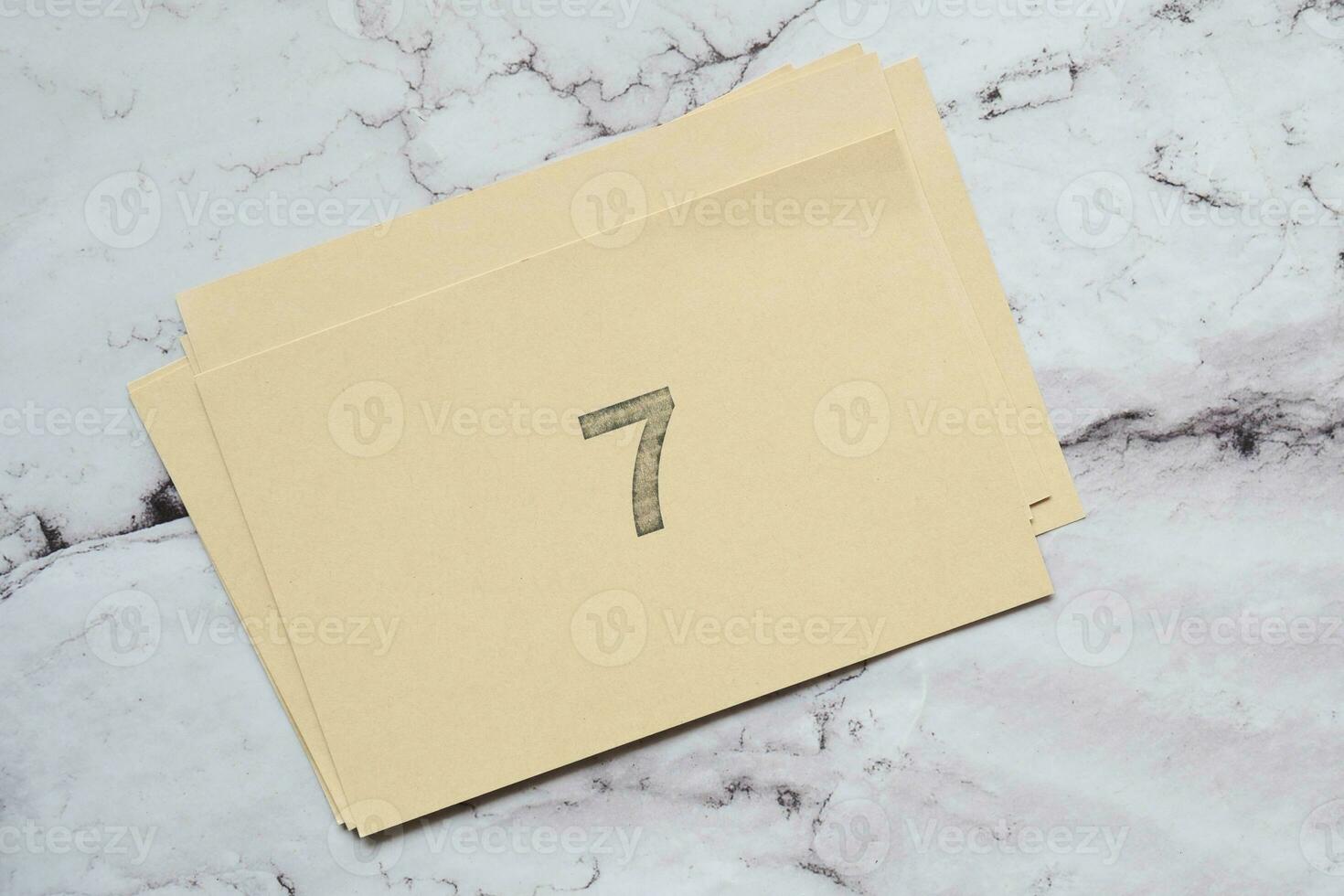 Number 7 icon, brown stick note on tile background photo