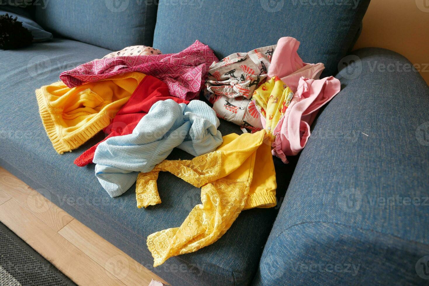 Messy clothes on sofa at home photo
