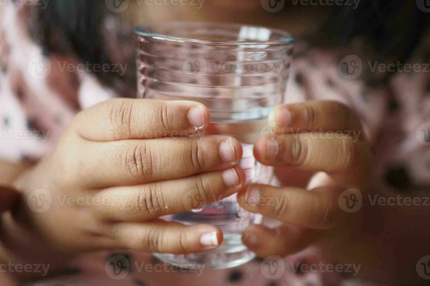 child hand holding a glass of water photo