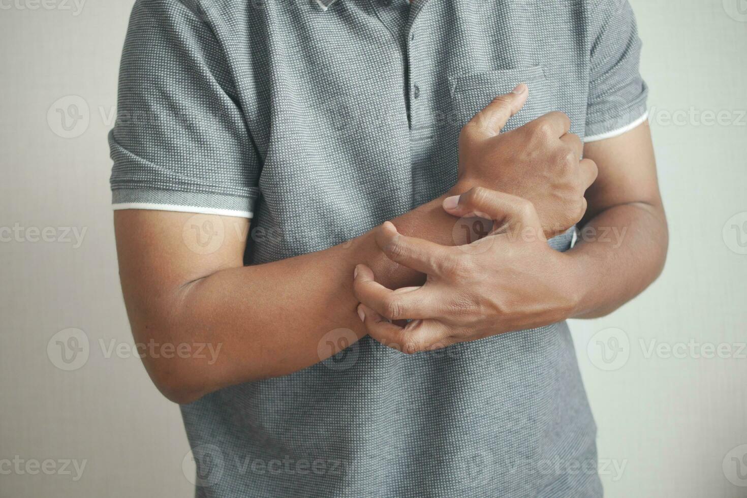 man suffering from itching skin, close up. photo