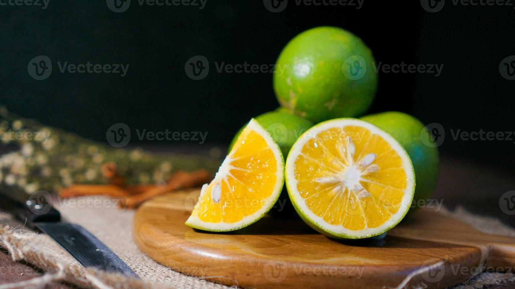 Orange fruit with green peel, half part, and slice with dark mood photography photo