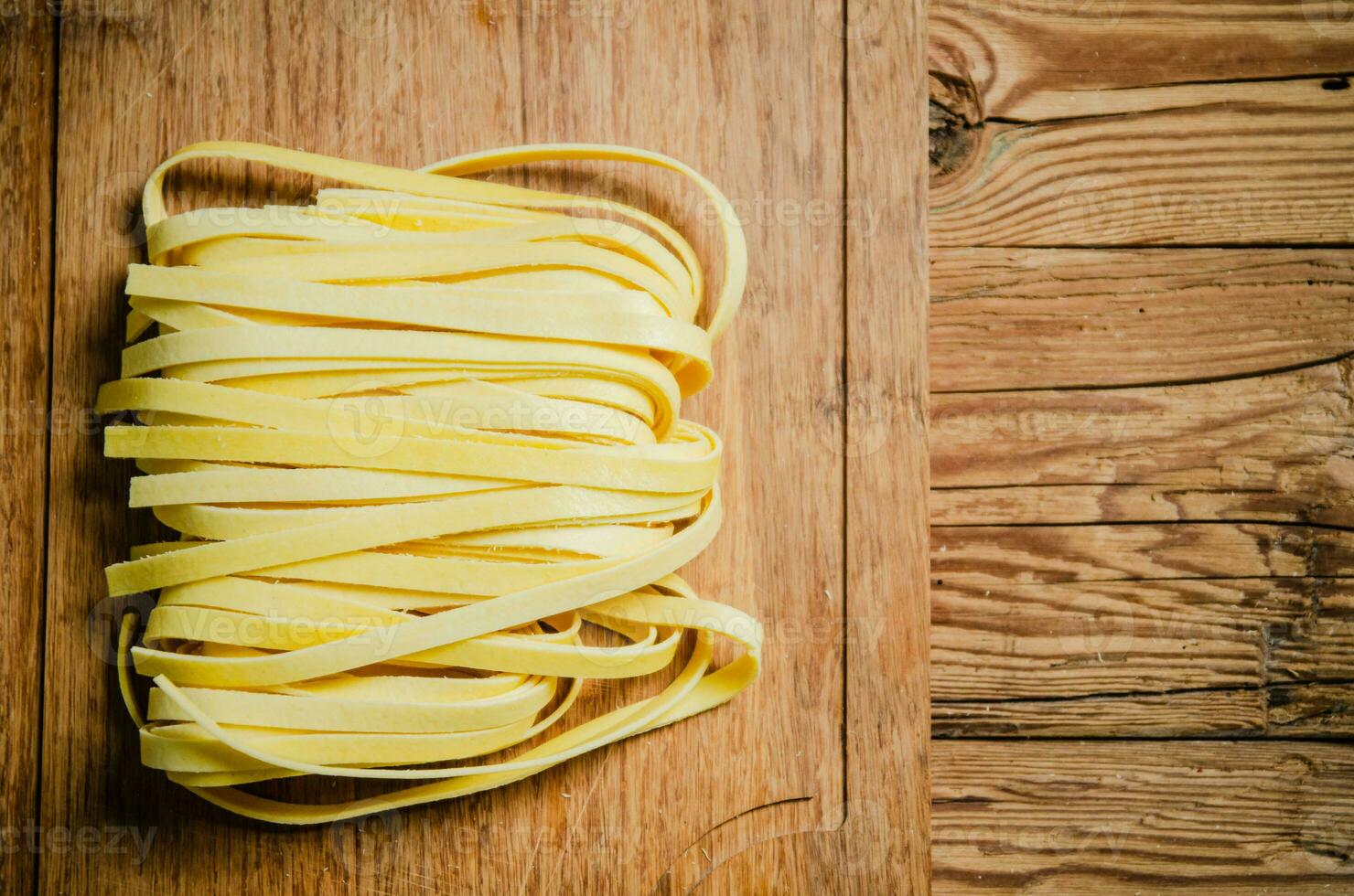Homemade pasta tagliatelle. On wooden table. photo