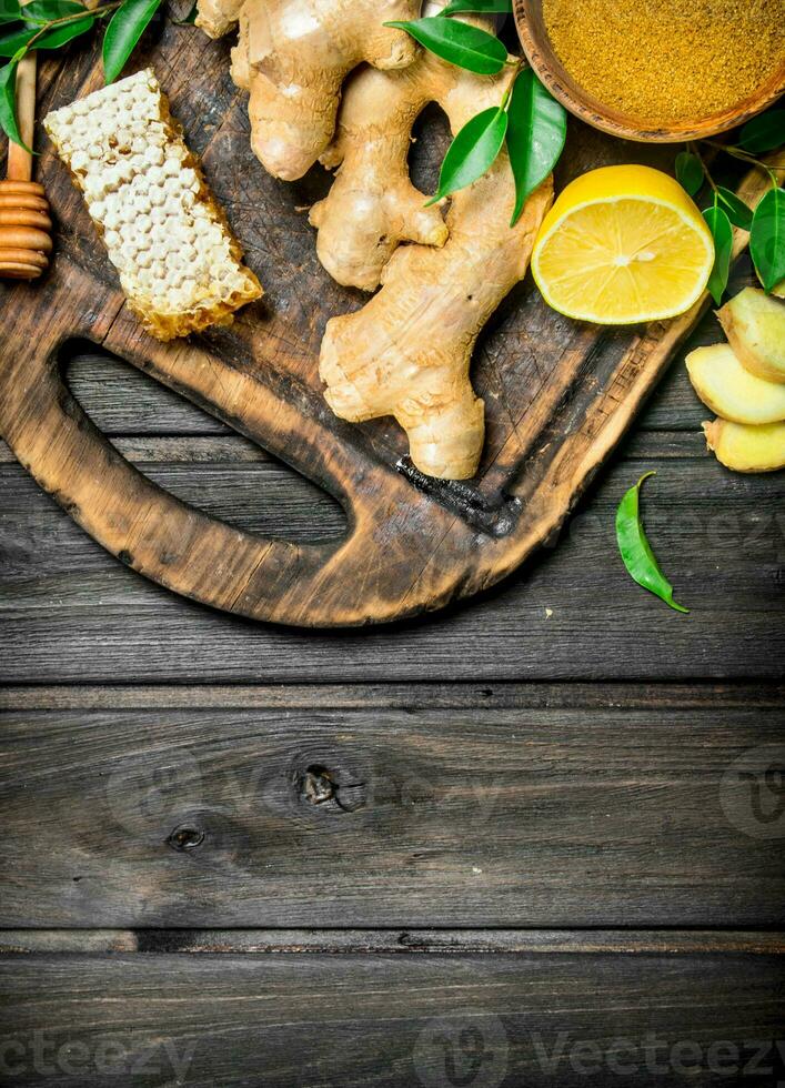 Ginger with lemon and honey on the cutting Board. photo