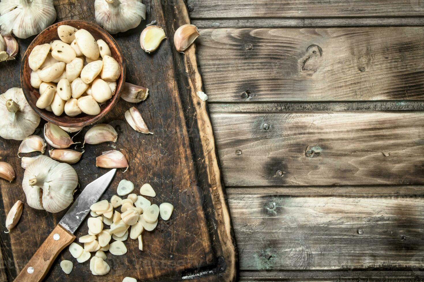 Garlic cloves on a cutting Board with a knife. photo
