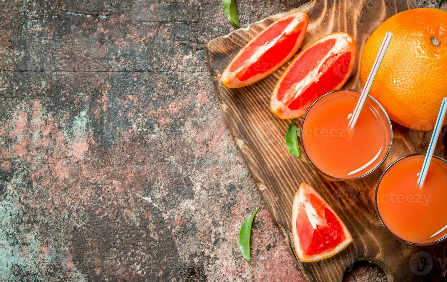 Grapefruit juice in a glass on a cutting Board. photo