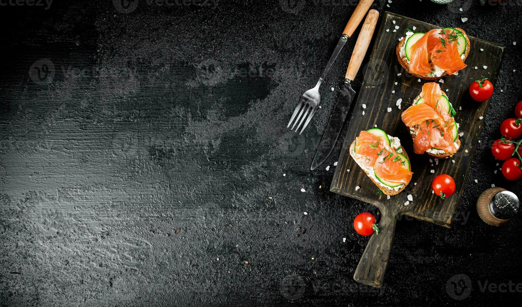 Sandwich with pieces of salmon on a cutting board. photo