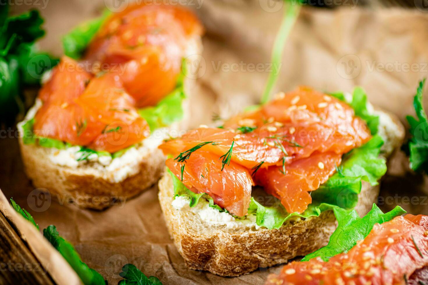 Salmon sandwich on paper. Macro background. photo
