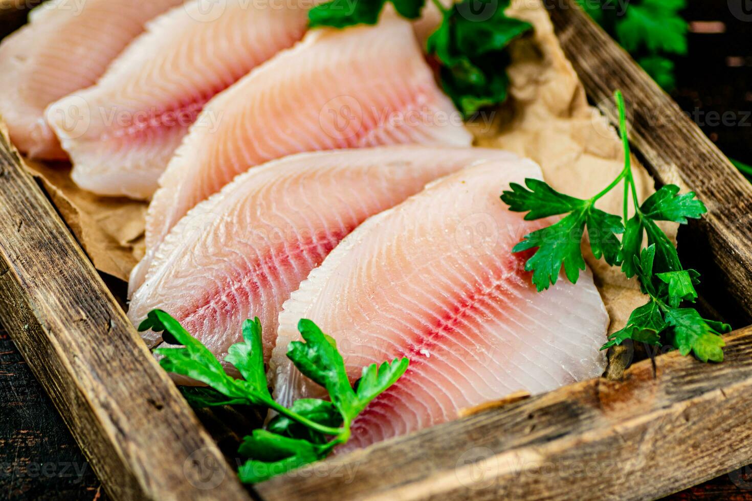 pescado filete con perejil en un de madera bandeja. foto